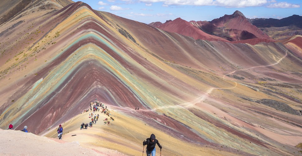 Rainbow Mountain is one of the earth’s most amazing natural phenomena. Forming part of the Peruvian Andes, it was draped underneath ice and snow until around 2012 when climate change caused the snow to melt. This uncovered the geological anomaly which has now become one of the most popular Cusco day trips. Cusco excursions will take you to the multi-colored mountain, but more important is to bear in mind the reasons why we are able to do so.
