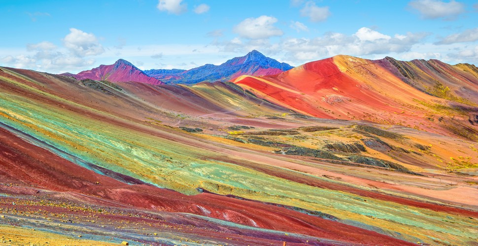 Rainbow Mountain is a geological marvel with vibrant stripes of rusty reds,  yellow, and turquoise. At an altitude of 5,200 meters (17,100 ft) above sea level, it creates a breathtaking spectacle against snow-capped peaks. No Peru adventures are complete without a visit to this natural wonder in The Andes.