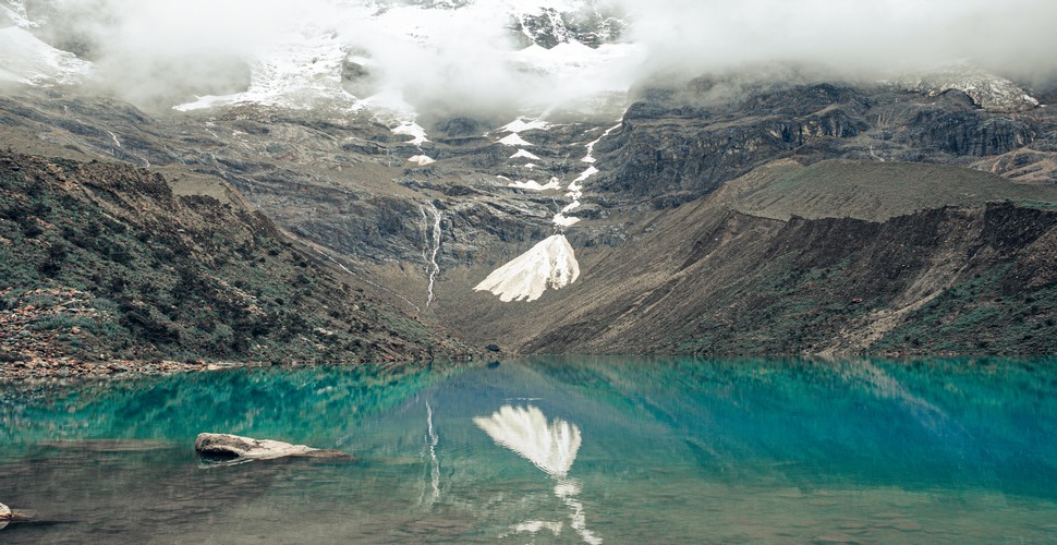 The lake's striking turquoise color is due to minerals from the surrounding mountains. It is surrounded by snow-capped peaks and the imposing Humantay Glacier, creating a dramatic and picturesque landscape. Visit Humantay Lake on Cusco day trips!